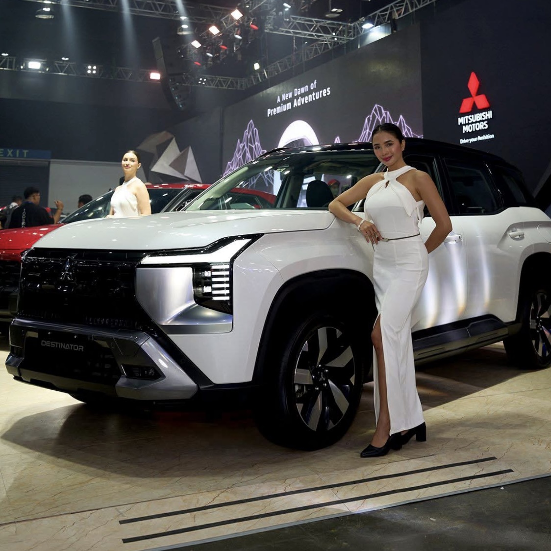 Nicci modelling beside a Mitsubishi Motors vehicle at a motor show