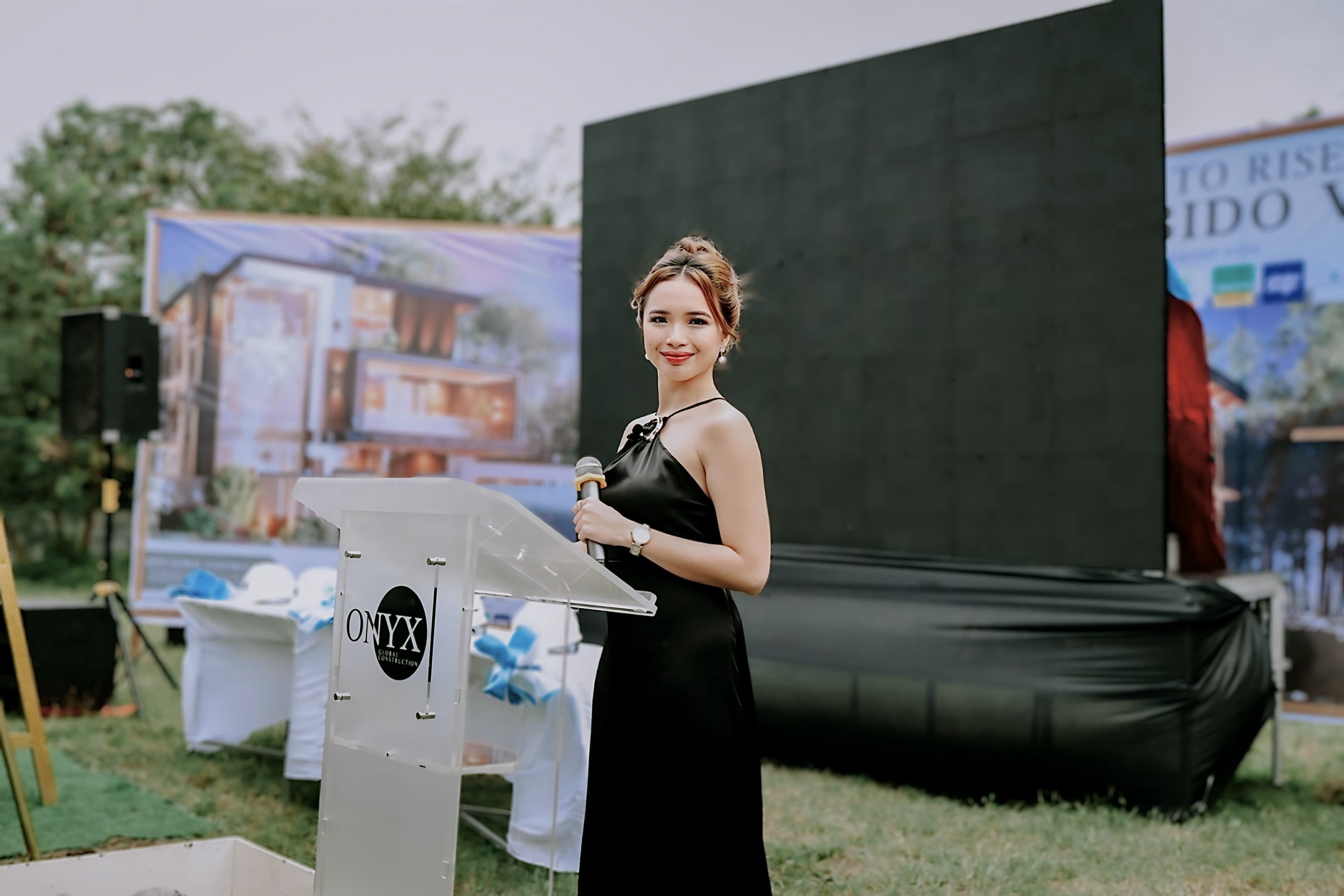 Nicci hosting a corporate groundbreaking event at a lectern